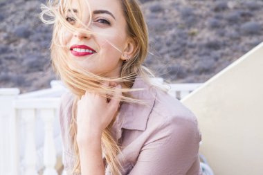 terasta duran kırmızı dudaklar ile gülümseyen sarışın kadın