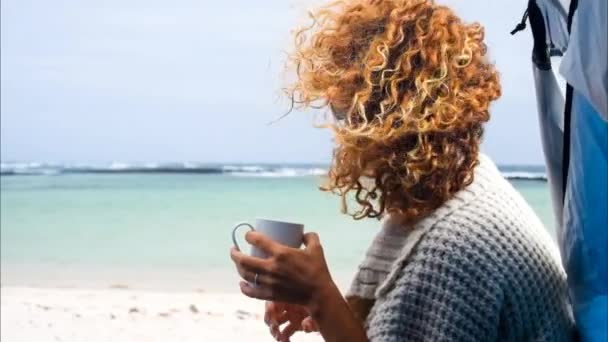 Vrouw Met Krullend Haar Zittend Het Strand Met Kopje Koffie — Stockvideo