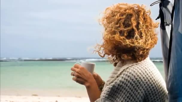 Vrouw Met Krullend Haar Zittend Het Strand Met Kopje Koffie — Stockvideo