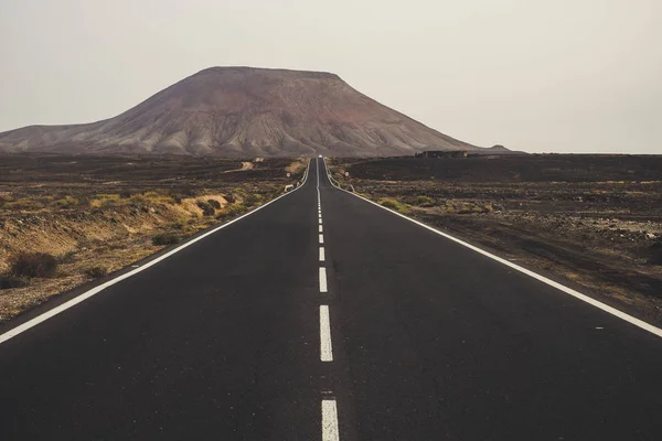 山と谷のピークの中間に長い道のアスファルトの道路 — ストック写真