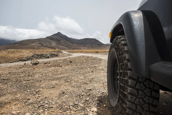 Wheel Black Car Desert Mountains Daytime — Stock Photo, Image