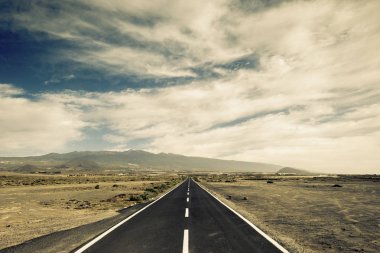 long way asphalt road in middle of mountains and valley peaks clipart