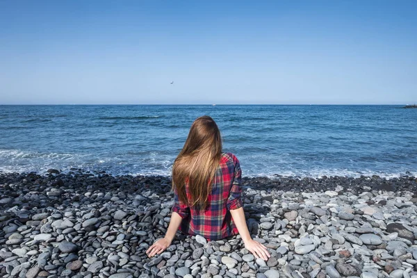 Visão Traseira Jovem Mulher Sentada Praia Perto Oceano Desfrutando Férias — Fotografia de Stock
