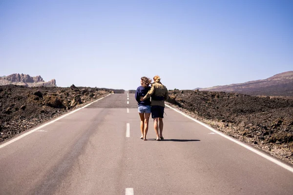 一对漂亮的年轻夫妇拥抱和走在长途路的后方视图 — 图库照片