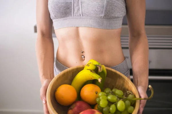 Perfekter Weiblicher Körper Mit Muskeln Und Hölzerne Schale Mit Früchten — Stockfoto