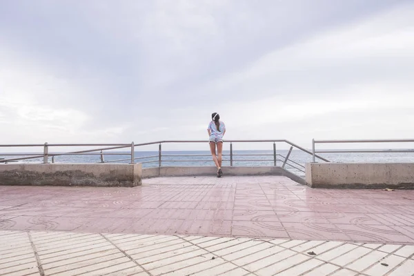 Visão Traseira Jovem Mulher Terraço Enquanto Ouve Música Fundo Oceano — Fotografia de Stock