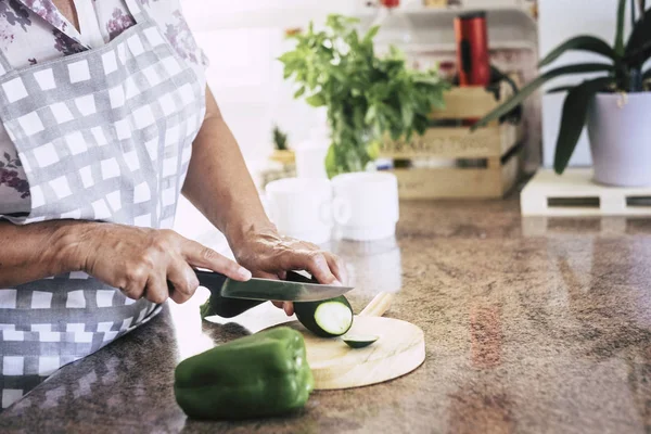 Kadın kıdemli kesme sebze evde mutfak