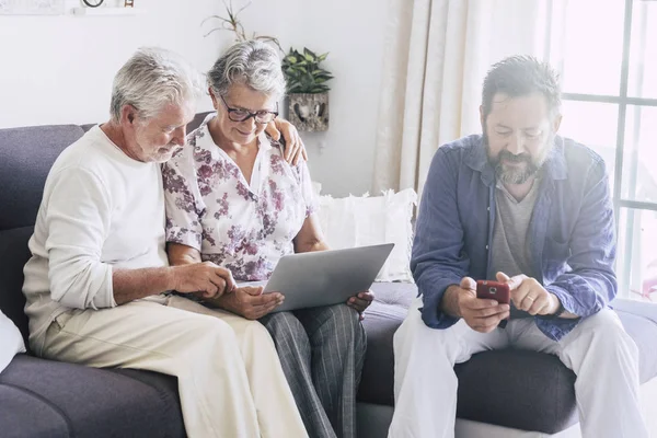 Familia Moderna Usando Ordenador Portátil Teléfono Inteligente Mientras Está Sentado —  Fotos de Stock