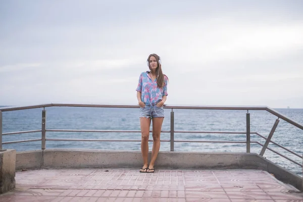 Jonge Vrouw Terras Terwijl Luisteren Muziek Oceaan Achtergrond — Stockfoto