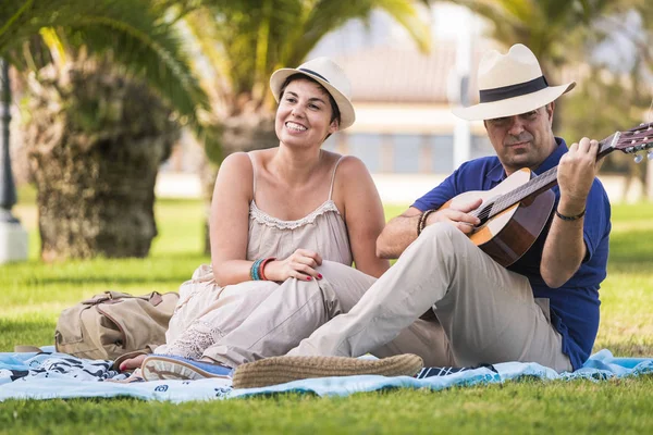 Paar Liggen Park Terwijl Man Spelen Gitaar — Stockfoto