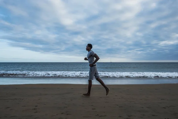 Африканский Мужчина Бежит Пляжу Облачном Фоне Неба — стоковое фото