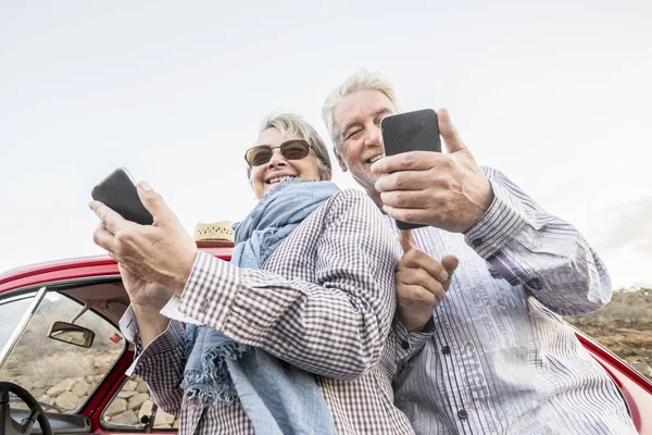 senior couple using smartphones, travel and vacation concept