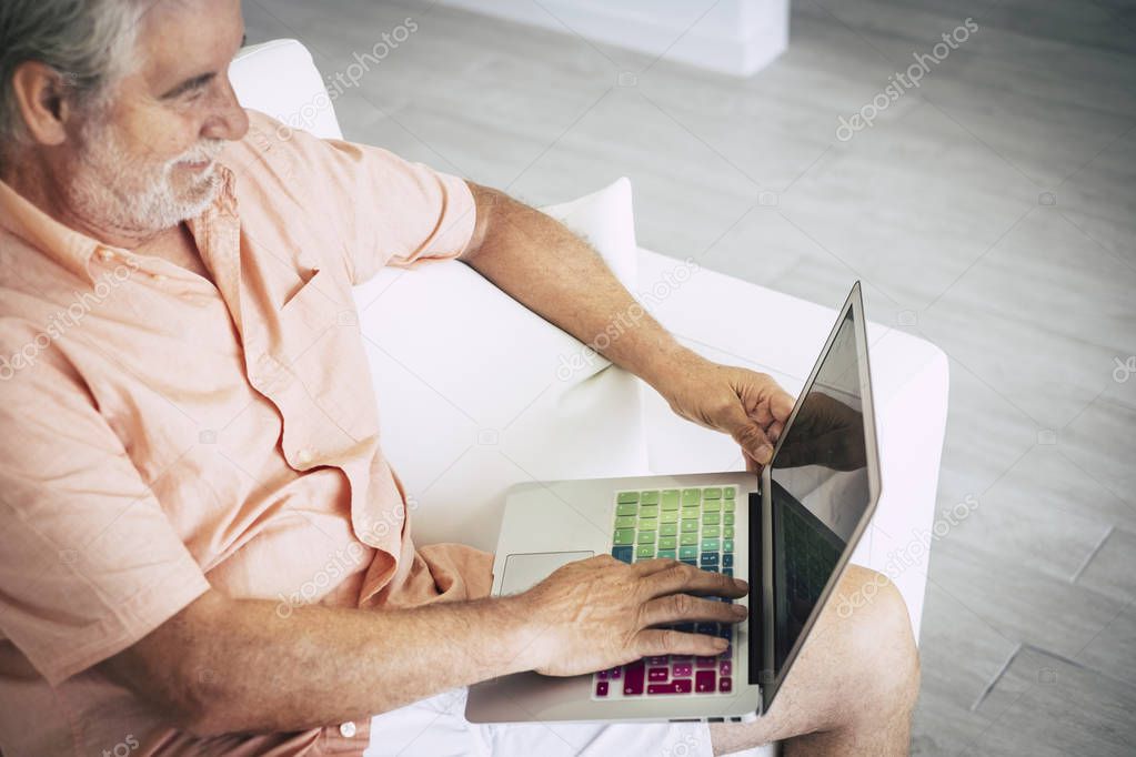 senior man using laptop with colorful keyboard