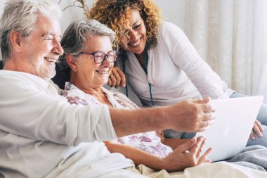 modern aile evde kanepede otururken dizüstü bilgisayar kullanarak 
