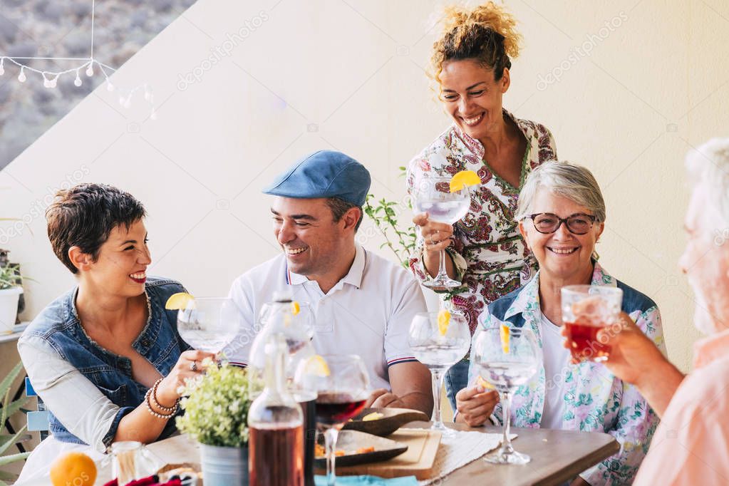 family celebrating together at home on terrace with food and wine