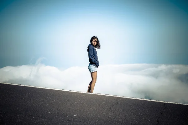 Молода Жінка Стоїть Асфальтній Дорозі Над Високими Горами Фоні Хмар — стокове фото
