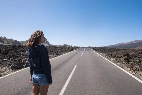 Молодая Женщина Идет Длинной Асфальтовой Дороге Посреди Пустыни — стоковое фото