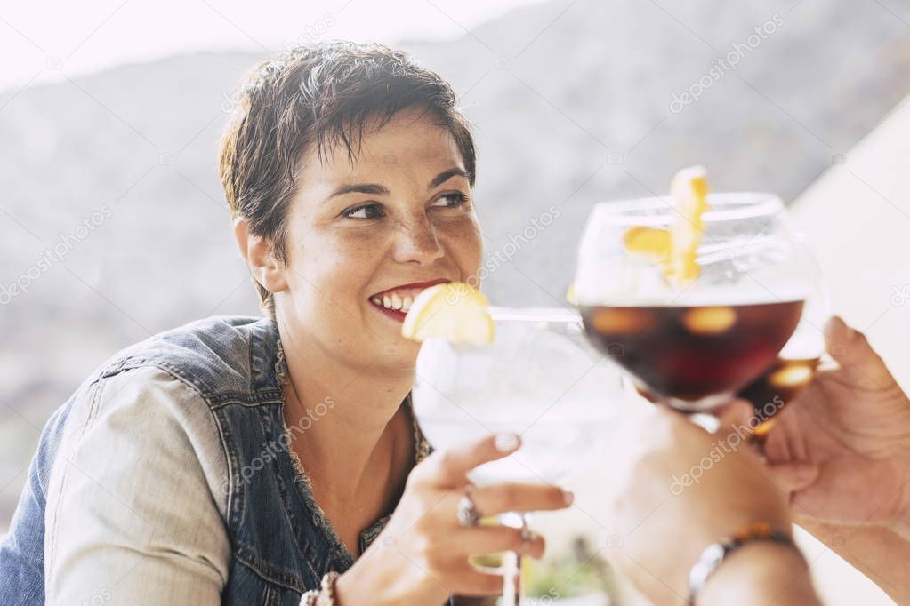 woman smiling and enjoying cocktail with friends outdoor