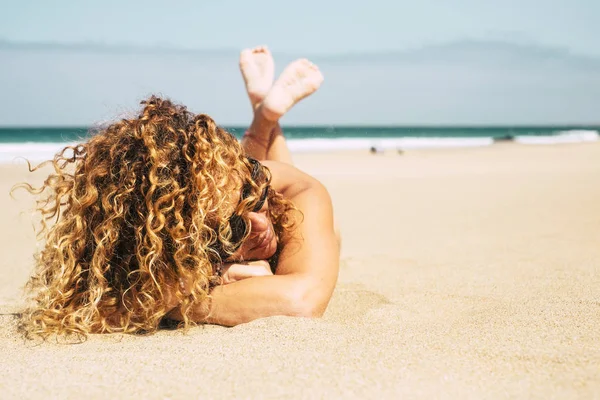 美丽的晒黑的女士卷曲的金发躺在海滩上的夏天 — 图库照片