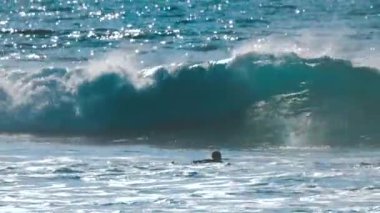 gün batımı arka plan üzerinde dalgalar deniz üzerinde yüzen sörfçü görünümünü