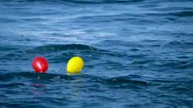 Çift için aşk ve sevgililer günü kavramı. Okyanusun mavi sularında yüzen kırmızı ve sarı balonlar.