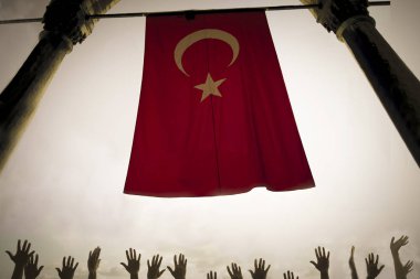 Siyaset ve din kavramı gökyüzüne karşı kırmızı bayrak ve birçok el dua ya da taç konsepti gibi 