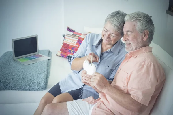 Happy Senior Couple Holding Wooden Handmade Heart While Sitting Sofa — Stock Photo, Image