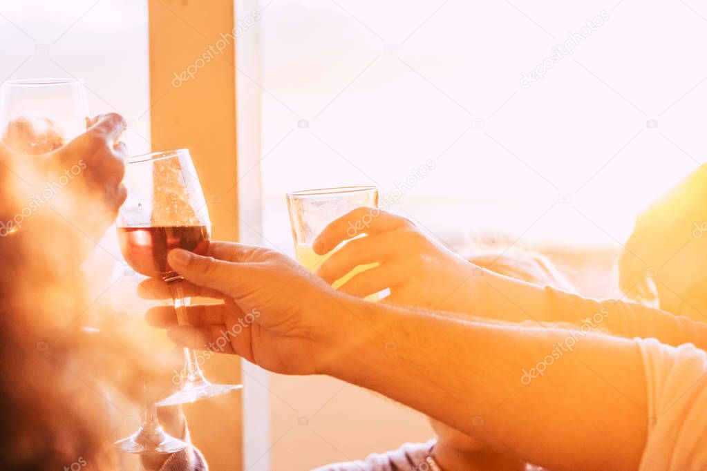 Close up of glasses cheering and toasting together with wine and beverages 