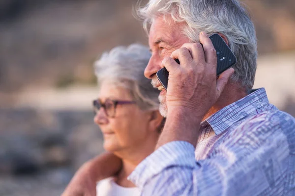 Pareja Anciana Abrazándose Mientras Hombre Habla Por Teléfono Inteligente — Foto de Stock