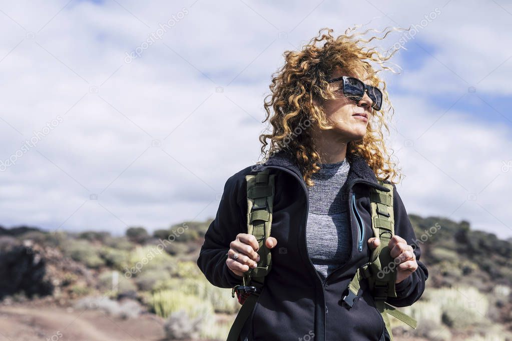 Young beautiful woman with backpack and trekking clothes in mountains