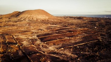 Toprakta tarlası olan hava manzarası. Toprak çöl ve arka planda okyanus olan dağlar. 
