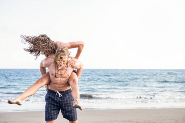 Genç çift rahatlatıcı ve kıyı şeridi tatil sırasında zevk