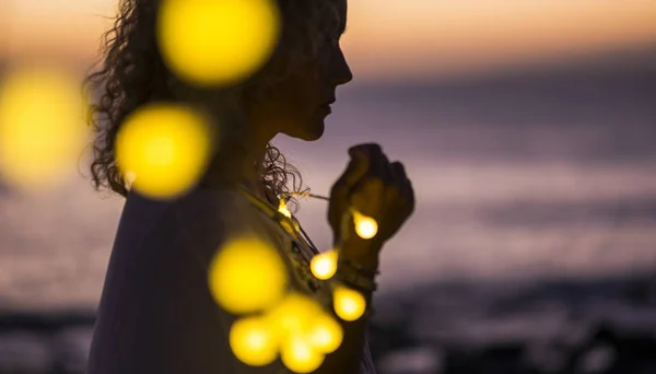 woman in shadow with yellow bulb lights