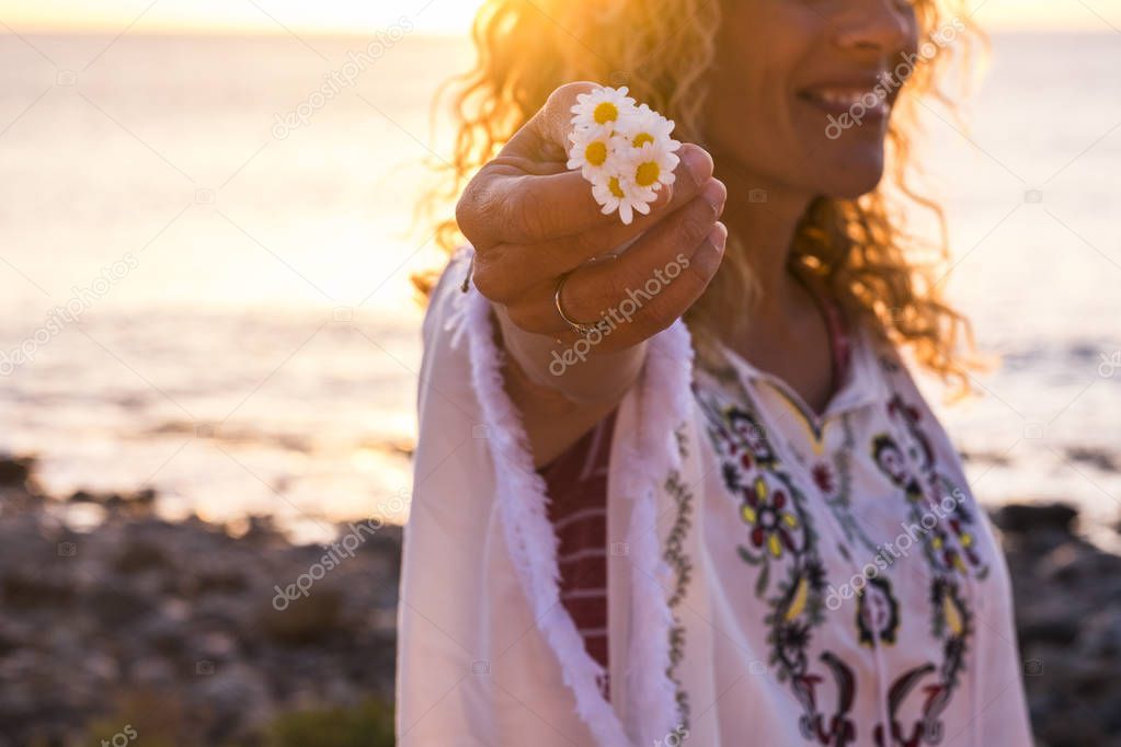 Cheerful happy free caucasian middle age woman in hippy fashion clothes take a beautiful daisy flowers