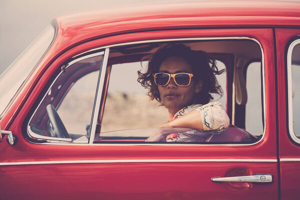 middle age lady driver posing inside of red legendary retro vintage car