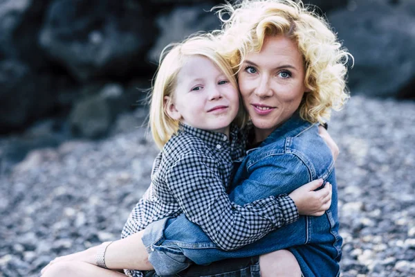 美丽的白种人年轻的金发母亲用爱心和爱心拥抱着她的小儿子 — 图库照片