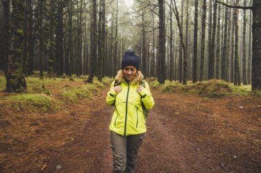 yüksek ağaçları ile ormanda gündüz yürüyen kadın