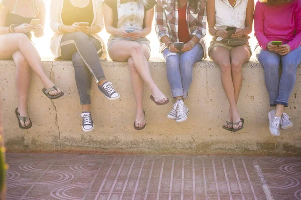 太陽の光をバックライトに夏の携帯電話技術を使用して友情の若い女性のグループ — ストック写真