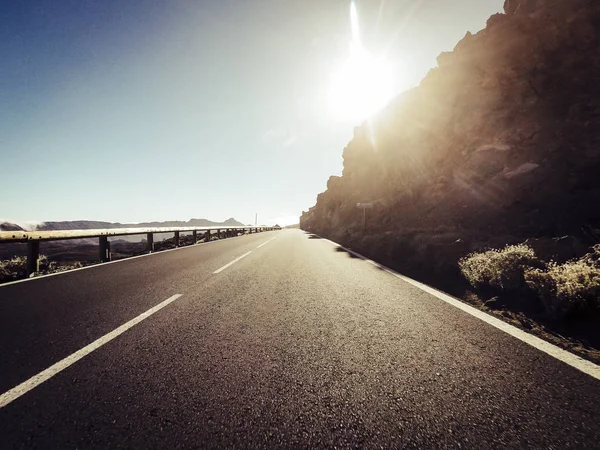 夕日を背景に山で長い方法道路 — ストック写真