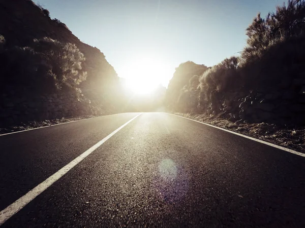 夕日を背景に山で長い方法道路 — ストック写真
