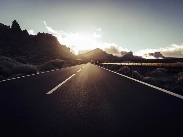 夕日を背景に山で長い方法道路 — ストック写真