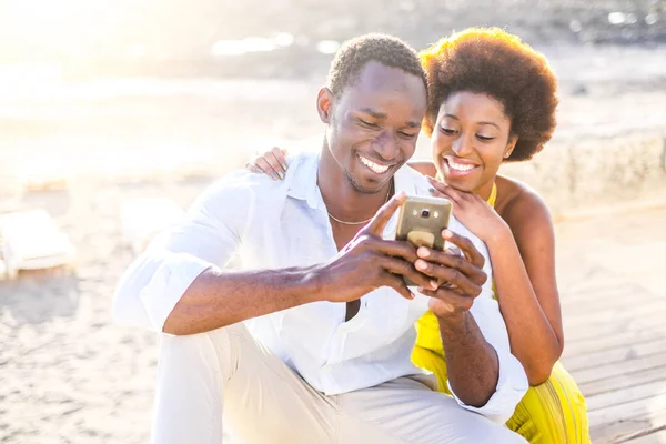 Feliz Casal Africano Sentado Praia Usando Smartphone Temporada Verão — Fotografia de Stock