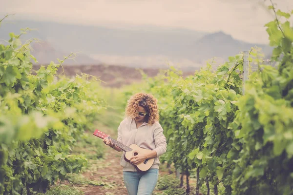 ブドウ畑でアコースティック ウクレレ ギターを演奏する屋外の女性 — ストック写真