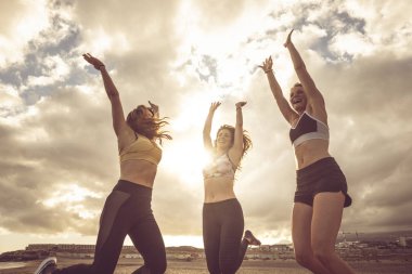 Spor başarısı için mutluluk ve sevinç aktif yaşam tarzı - bir grup güzel bayan arkadaş zafer için havaya atlıyor 