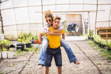 Genç ve güzel bir kız annesiyle oynuyor. Orta yaşlı, güzel bir kadın onu sırtında taşıyor.