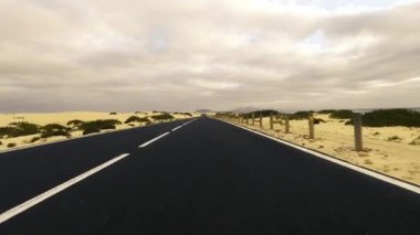 Çöl boyunca boş yolda giden araba, seyahat kavramı.