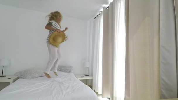 Young Blonde Curly Long Hair Jumping Bed Home Bedroom Happiness — Stock Video