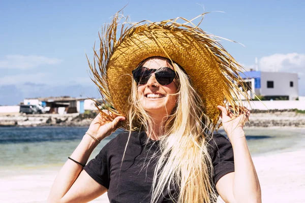 아름다운 금발의 아름다운 해변의 바다를 배경으로 휴가를 즐기며 아래서 모자를 — 스톡 사진