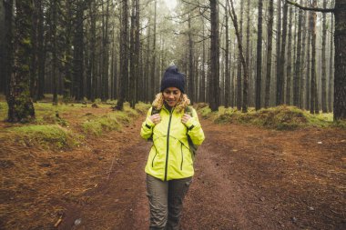 yüksek ağaçları ile ormanda gündüz yürüyen kadın