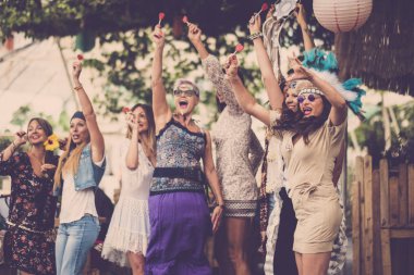 Genç kadınlar ve kızlar hep birlikte biyo-doğal bir yerde kutlama yapıp eğleniyorlar. Bir grup hippiye gülüyor ve gülüyor alternatif konsept yaşam tarzı